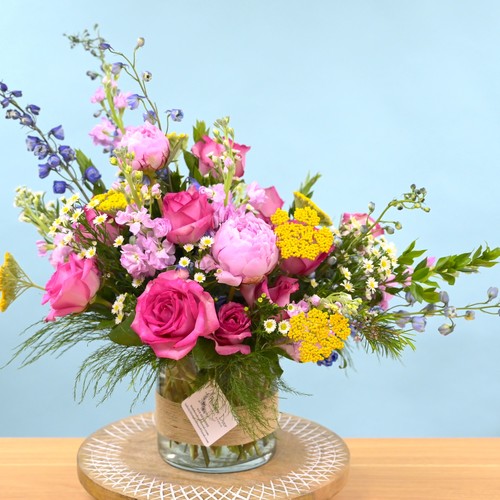 Pink roses and peonies with yellow yarrow and blue delphinium by top florist Raleigh NC