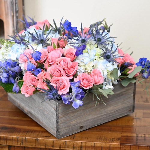 Pink roses with blue thistle and hydrangeas in rustic wooden box from Raleigh NC florist