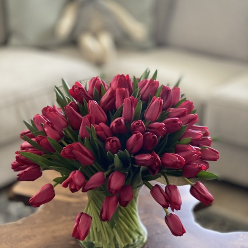 Deep red tulip bouquet on live-edge wood table by top florist Raleigh NC